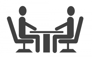 Clip art of two persons facing each other at table