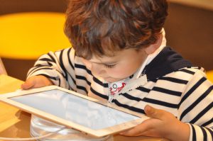 Photo of child looking at computer tablet
